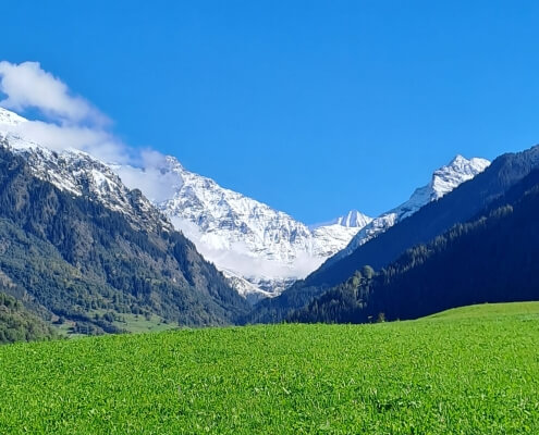 Autumn in Verbier with snow-covered mountain tops, showcasing a beautiful contrast of fall foliage and early winter snow in the Swiss Alps."