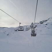 Skiers riding a chairlift at Lac des Vaux in Verbier on the first weekend of the 2025/26 winter season, surrounded by fresh early snow.