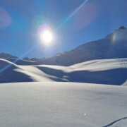 Sunlit fresh snow and mountain ridges in Val d’Isère during early-season skiing.