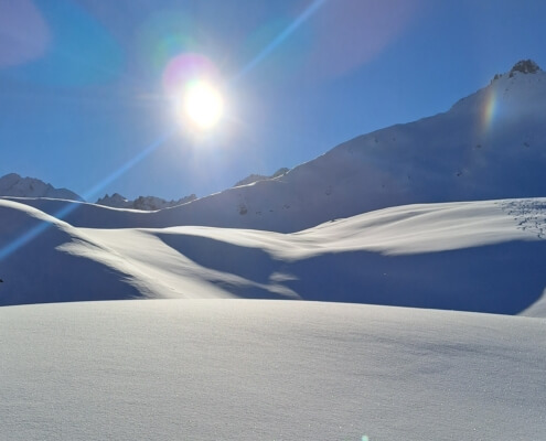 Sunlit fresh snow and mountain ridges in Val d’Isère during early-season skiing.