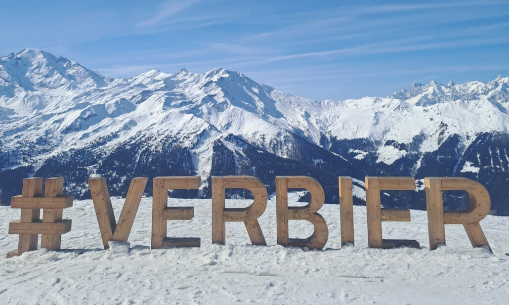 Things to do in Verbier Switzerland mountain view with #Verbier sign and snowy Alps