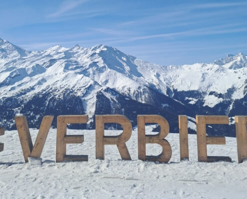 Things to do in Verbier Switzerland mountain view with #Verbier sign and snowy Alps