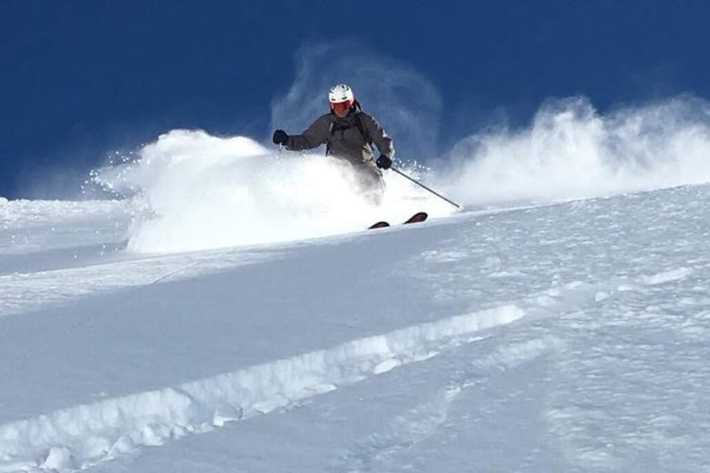 Off Piste Powder Skiing in Verbier Skier making dynamic turn in deep powder during off piste ski lesson in Verbier