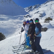 Private ski instructor skiing with clients in Verbier on a sunny winter day