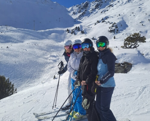 Private ski instructor skiing with clients in Verbier on a sunny winter day