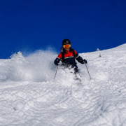 Skier skiing powder snow under a blue sky in Verbier Switzerland
